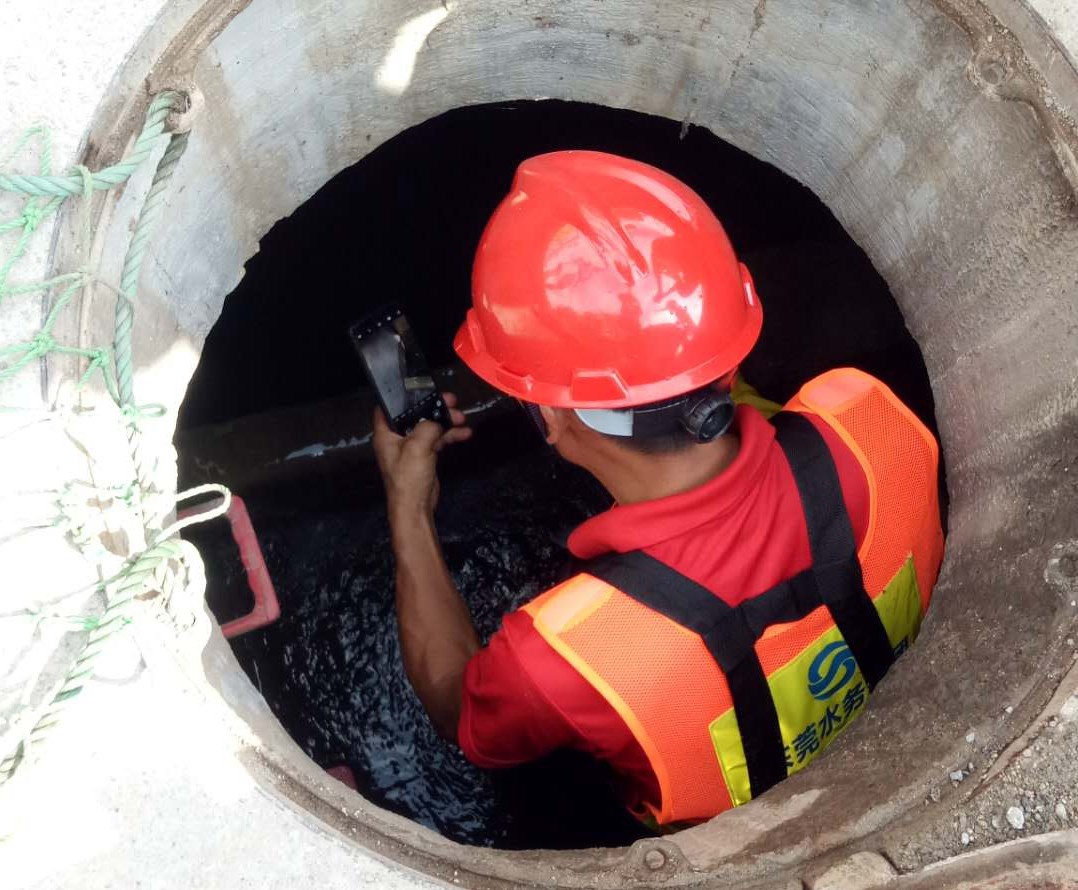 13-圖為水務(wù)工程公司黨員排查污水井內(nèi)是否有堆積垃圾、水流是否暢通等情況.jpg